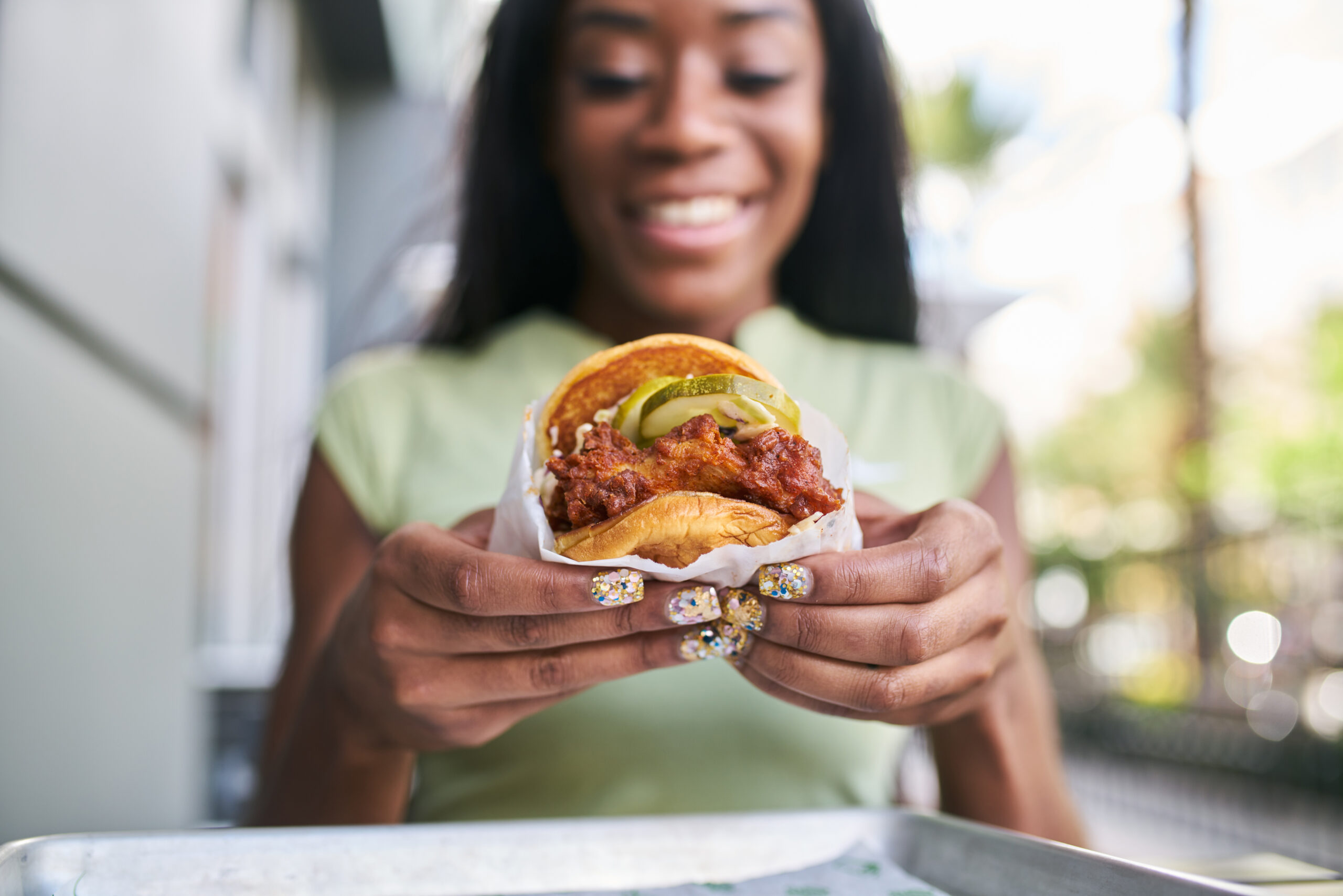 Woman holding a burger and smiling