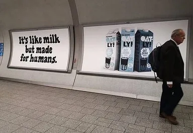 Oatly posters in the subway, one has Oatly products on them, the other says "it's like milk but made for humans"