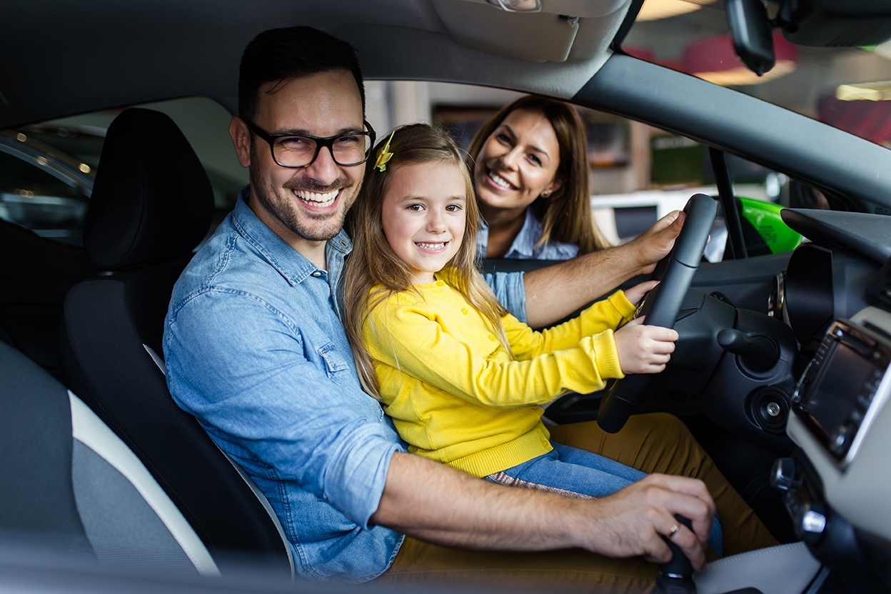 AdobeStock_232776102 family smiling in a car