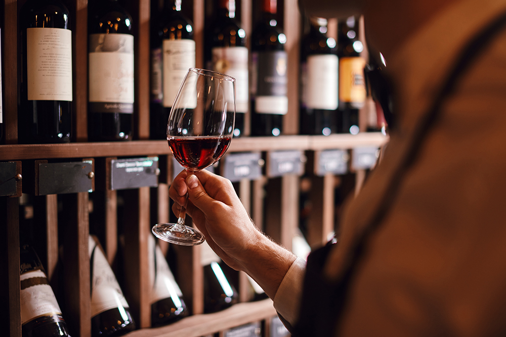 Person holding a glass of wine in store